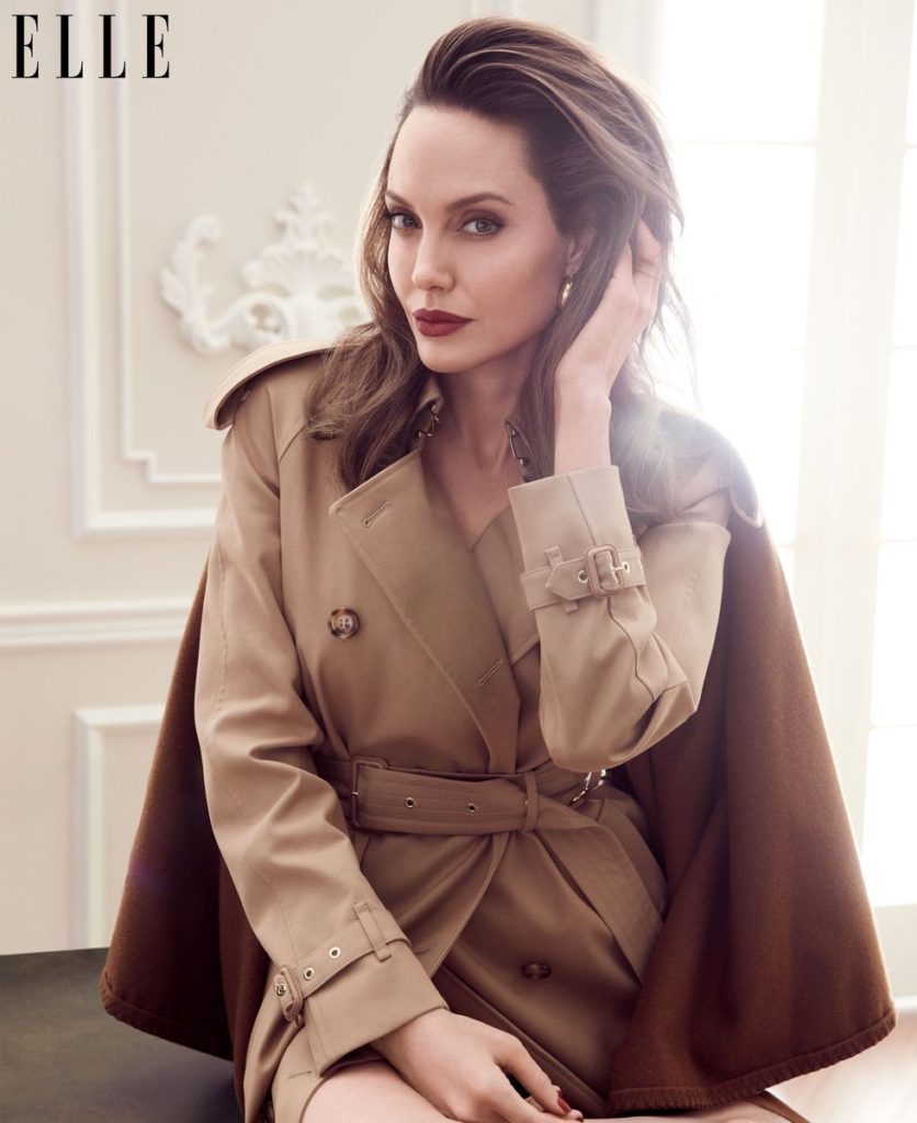 Angelina Jolie Wears A Trench coat with cape, Burberry. Earrings, Rosantica.